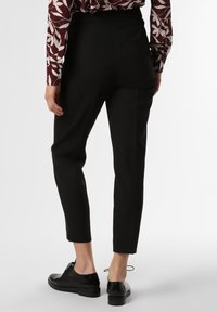 Svarta skräddarsydda byxor med slim fit, med en slät textur, beskuren längd och subtila sidofickor. Bärs tillsammans med svarta snörskor.