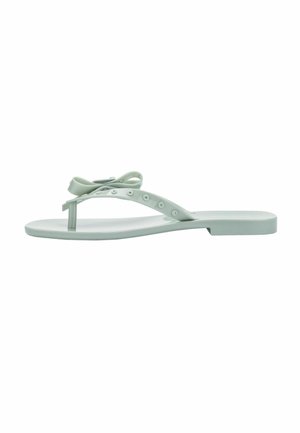 Une sandale plate de type flip-flop gris clair avec une bride entre les orteils et un nœud décoratif sur le dessus, vue de côté.
