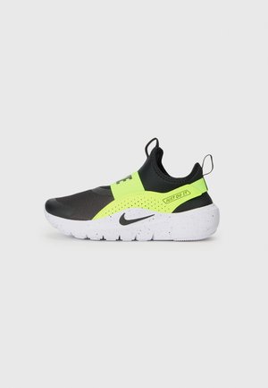 Sneaker noir et vert fluo à enfiler avec une tige texturée, un bout rond et une semelle parsemée de blanc. Présente un label "Just Do It" et des languettes de tirage.