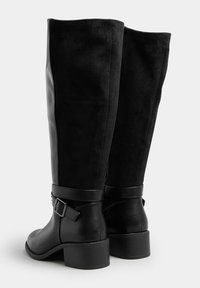 Czarne kozaki sięgające do kolan, wykonane z mieszanki gładkiej skóry i zamszu, z wyraźnym detalem klamry oraz niskim, słupkowym obcasem dla większej stabilności.