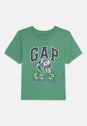 Žalios spalvos trumpomis rankovėmis marškinėliai su užrašu „GAP“ ir animaciniais personažais Buzz Lightyear bei trimis žaliais ateiviais iš „Žaislų istorijos“ priekyje.