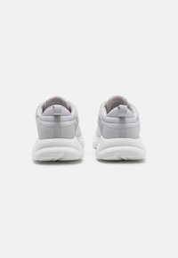 Szare buty sportowe z teksturowanym tyłem, wyściełanym kołnierzem i białą gumową podeszwą. Posiadają uchwyt i gładki materiał syntetyczny.