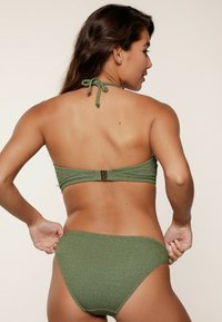 Zielony bikini w teksturę, składający się z topu na halter oraz dopasowanych majtek z wysokim stanem, z zapięciem na plecach.