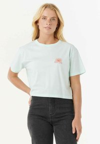 Licht mintgroen cropped t-shirt gemaakt van zachte katoen, met een kleine oranje zongrafiek en de merknaam "Ripcurl" op de borst.