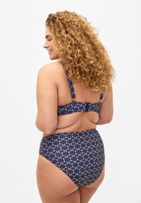Niebieski bikini w geometryczny wzór w kolorze kremowym. Posiada szersze ramiączka i zapięcie na plecach. Spódki z wysokim stanem zapewniające zakrycie i wsparcie.