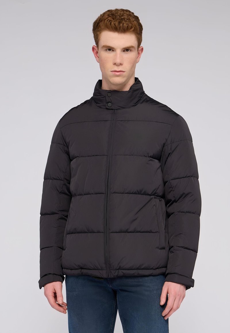 Svart vadderad jacka med hög krage, med horisontellt quiltade sektioner, dragkedja framtill och sidofickor. Mjuk, slät textur.