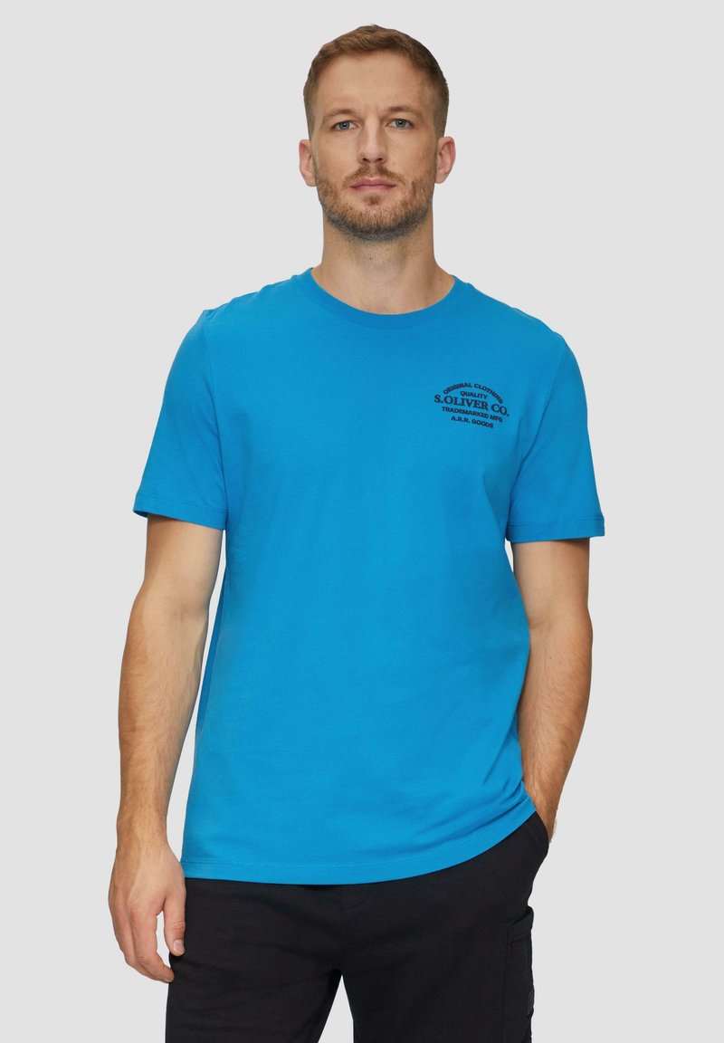 Korte mouwen crew neck t-shirt in helderblauw katoen, met zwart bedrukte branding nabij de linker borst, gladde textuur en reguliere pasvorm.