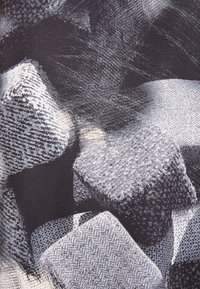Tejido gris estampado que presenta un diseño de espiga texturizada, con formas irregulares y áreas lisas en contraste. Alto contraste en general.