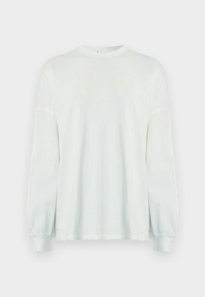 Cămașă albă cu mâneci lungi, realizată din material ușor. Are decolteu rotund și mâneci bufante pentru un fit relaxat. Design simplu.