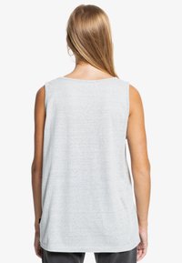 Ljusgrå ärmlös topp, tillverkad av mjukt tyg; har en rund halsringning och en lös passform med en rak fåll i ryggen.