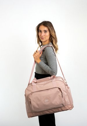 Hellrosa Sporttasche mit zwei Griffen und einem abnehmbaren Schultergurt. Verfügt über eine Vordertasche und ein strukturiertes Gewebe.