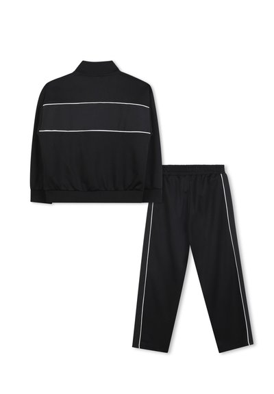 Tuta nera con giacca con zip e colletto, dotata di strisce bianche sul petto, abbinata a pantaloni coordinati con elastico in vita.