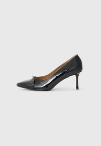 Sorte patent lær høyhælte sko med spiss tå, dekorativ stroppdetalj foran og tynn stiletthel.