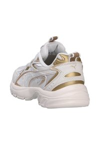 Scarpe da ginnastica bianche con dettagli dorati, tessuto in rete, colletto imbottito e suola testurizzata. Presenta un'impugnatura sulla parte posteriore.