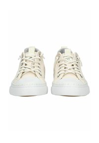 Sneakers in tela di un leggero beige con suole in gomma bianca, dotati di lacci, occhielli in metallo e una punta testurizzata.