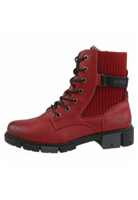 Bottine en cuir rouge à la cheville avec un panneau en tissu côtelé et une sangle noire, dotée d'œillets en métal, de lacets noirs et d'une semelle en caoutchouc épaisse.