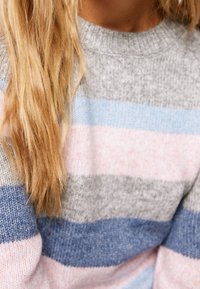 Suéter de punto con rayas horizontales en gris, azul y rosa, con cuello redondo y textura suave. Primer plano del detalle de la tela.