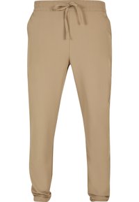 Pantalon de jogging décontracté beige pour homme avec taille élastique, cordon ajustable, poches latérales et jambes fuselées.