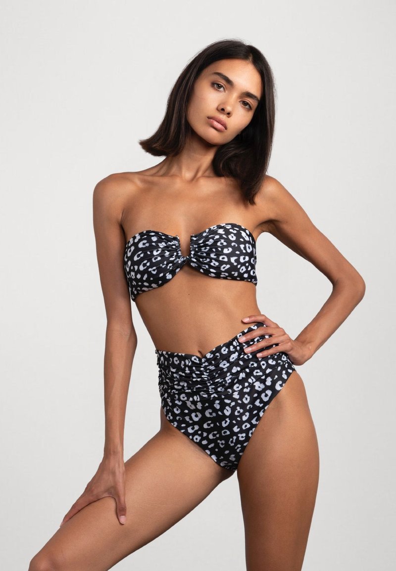 Zwart-witte luipaardprint bikini met een bandeau-top met ruches en een hoogblauw bottom met geplooide textuur.