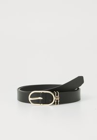 Ceinture en cuir noir avec une boucle ovale dorée. La sangle est lisse et plate, avec un minimum de couture et un design épuré.
