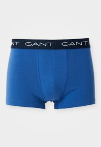 Kék pamut boxernadrág sötétkék elasztikus derékkal, amelyen a "GANT" márkaneve fehér betűkkel van emblémázva. Simára kidolgozott textúra, testhezálló kivitel.