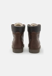 Botas de tobillo de cuero marrón con un cuello plegado en marrón oscuro y forro de piel sintética. Suela de goma resistente y detalles de costura decorativa.