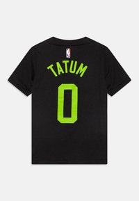 T-shirt en coton noir avec des lettres vert fluo "TATUM" et "0" au dos, et un petit logo NBA au niveau du cou.