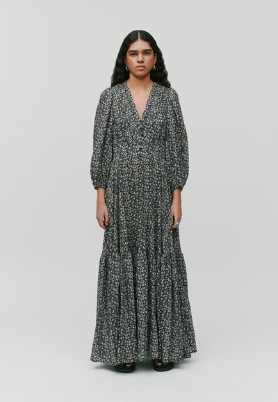 Maxikleid mit tiefem V-Ausschnitt, langen Puffärmeln, schwarzem Stoff mit weißem Blumendruck und gestuftem Saum. Glatte Textur.