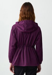 Paarse lichte jas met een capuchon, trekkoord in de taille en elastische manchetten. Glad oppervlak met een ontspannen pasvorm en geen zichtbare sluitingen.