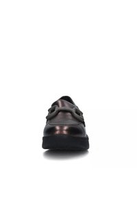 Scarpe metalliche in bronzo con punta arrotondata, suola in gomma e due fibbie decorative sulla parte superiore. Texture liscia con una leggera lucentezza.