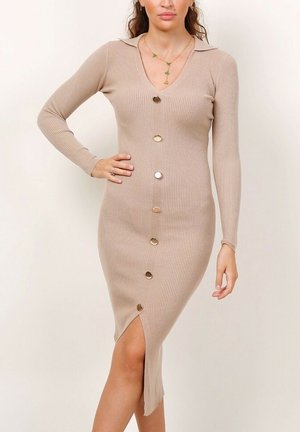 Robe beige côtelée à manches longues, décolleté en V, fermeture à boutons à l'avant et fente sur le côté pour une touche de style. Équipée de boutons dorés.