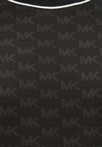 Μαύρο μπλουζάκι με επαναλαμβανόμενο μοτίβο λογότυπου MK σε ελαφρώς πιο σκούρα απόχρωση. Διαθέτει στρογγυλή λαιμόκοψη με αντίθετη λευκή επένδυση.