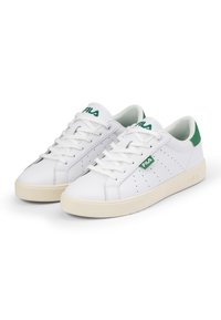 Sneaker in pelle bianca con accenti verdi, dettagli perforati, lacci piatti e suola in gomma color crema. Logo "FILÀ" sulla linguetta e sul lato.