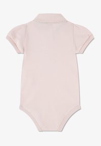 Ροζ ανοιχτό φανελάκι μωρού σε στυλ πόλο με κοντά μανίκια, απαλό ύφασμα και ριμπ πλάγιο γιακά. Διαθέτει κλείσιμο με κουμπιά στο κάτω μέρος για εύκολο ντύσιμο.