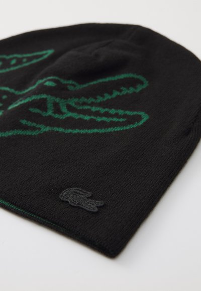 Bonnet en tricot noir avec un design de crocodile vert. Comprend un patch logo Lacoste noir. Texture douce avec un ajustement serré.