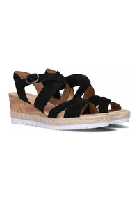 Black wedge sandals with crisscross suede straps, cork-like textured base, rope details along the sole, and a white rubber outsole.