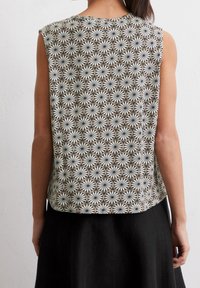 Hihaton paita, jossa on kuvioitu kangas, jossa on pyöreitä kuvioita hillityissä kerma- ja ruskean sävyissä, rento istuvuus ja pyöristetty helma.