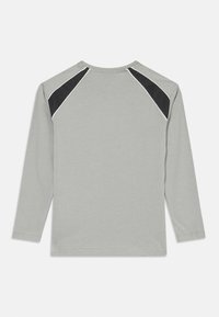 Langarm-T-Shirt aus hellgrauer Baumwolle mit schwarzen Mesh-Akzenten an den Schultern und weißen Paspelierungen, glatte Textur und regulärer Schnitt.
