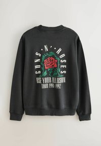 Hanorac negru cu un grafic de trandafir roșu și frunze verzi, textul "Guns N' Roses" și "Use Your Illusion Tour 1991-1992" pe spate.