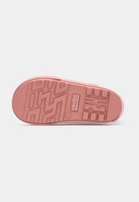 Suola in gomma rosa di una scarpa con profondi motivi di battistrada e testo "Made in China" impresso vicino al centro.