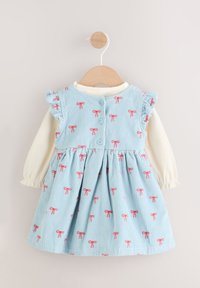 Modra kordurova obleka z rožnatimi vzorci pentelj, nagubani poudarki na ramenih in belo dolgo majico spodaj; gumb na zadnji strani.