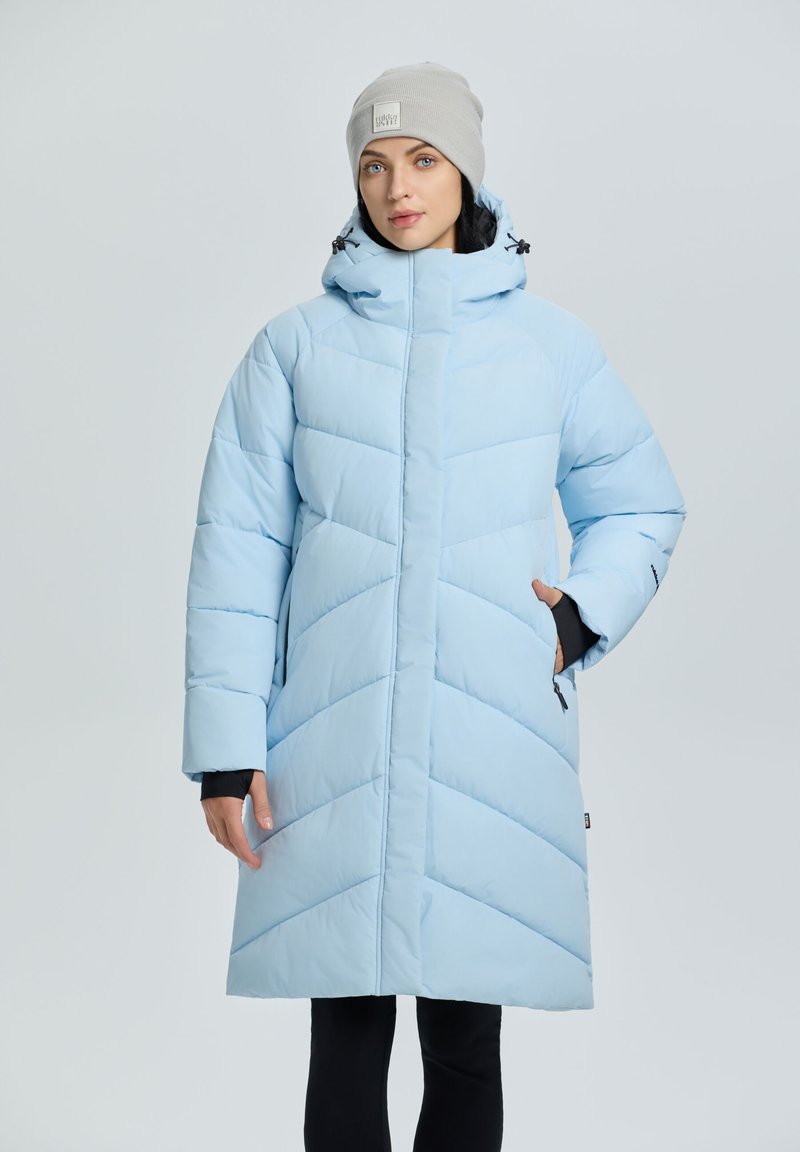 Abrigo acolchado azul claro con un cuello alto, acolchado en forma de flecha y bolsillos laterales. Presenta una textura suave y mangas largas.