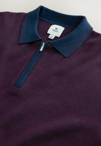 Burgundi színű pólóing tengerészkék gallérral, félcipzárral és két tengerészkék csíkkal a galléron. Puha tapintású, hétköznapi stílusú.