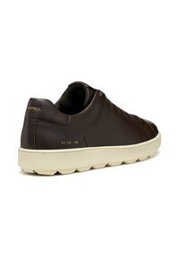Zapatillas de cuero marrón con punta redonda, acabado texturizado y suela de goma crema. Presenta un diseño minimalista y un sutil logotipo dorado.