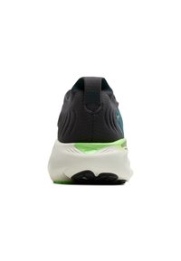 Zapatilla de running con una parte superior de textil gris oscuro, detalles verdes, talón acolchado y una entresuela blanca. Presenta un diseño texturizado y una suela de goma.