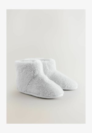 Hallid kunstkarvaga pahkluu-saapad pehme tekstuuri, ümarate varvaste ja valge kummist tallaga. Disain on lihtne ja hubane.