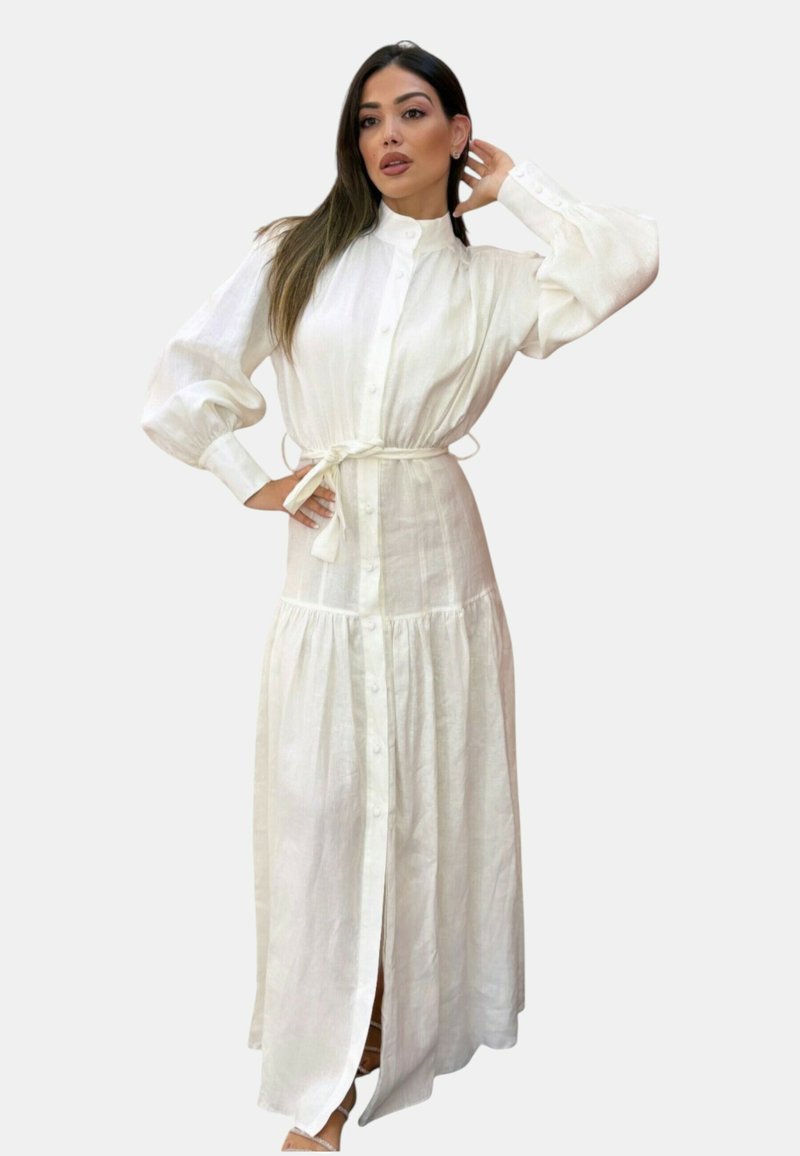Abito maxi bianco con bottoni, maniche a sbuffo lunghe, vita con laccetto e gonna a strati. Realizzato in tessuto leggero, presenta una chiusura frontale completa con bottoni.