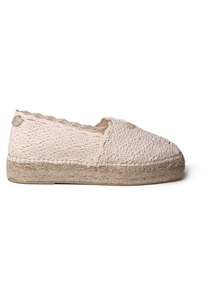 Beige hæklet slip-on espadrille med flettet jutesål og detaljer med bølget kant, set fra ydersiden.
