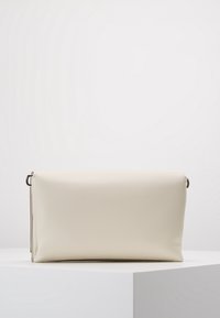 Borsa a pochette rettangolare di colore crema realizzata in pelle sintetica liscia. Presenta una chiusura con zip e un anello in metallo per il fissaggio della tracolla.