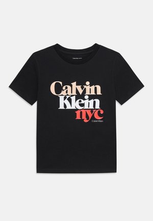T-shirt en coton noir avec un design graphique multicolore représentant "Calvin Klein nyc" en beige, blanc et rouge. Manches courtes, col rond.